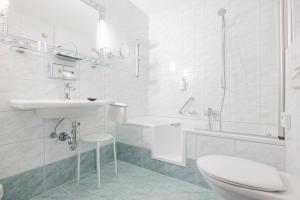 a white bathroom with a toilet and a sink at Hotel Schönegg in Seefeld in Tirol +47 photos