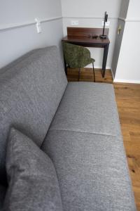a couch in a living room with a desk at Palazzo Hotel in Mannheim