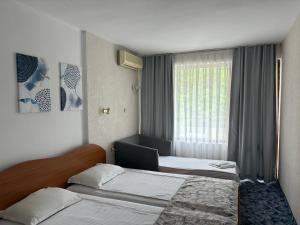 a hotel room with two beds and a window at Kamchia Park Hotel - All Inclusive in Golden Sands +21 photos