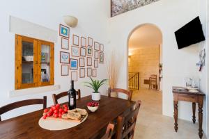 a dining room with a table with a bottle of wine at Tre Volte Belle - Salento Selection in Carpignano Salentino