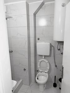 a white bathroom with a toilet and a sink at Apartman City 2 With 2 Bedrooms and Free Parking in Negotin