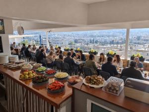 a group of people sitting at a bar with food at Hotel Efesian B&B City Center - Harbour in Kuşadası