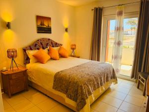 a bedroom with a bed with orange pillows and a window at Santa Maria Ilha do Sal T2 Apartament with pool A&L em Vila Verde in Prainha +61 photos