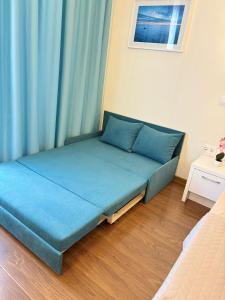 a bed in a room with blue curtains at Adela Sunset View by Blaxy Resort in Olimp +39 photos