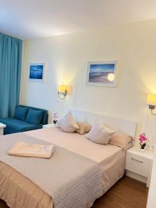 a hotel room with a bed and a blue couch at Adela Sunset View by Blaxy Resort in Olimp