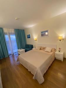 a bedroom with a large bed and a blue couch at Adela Sunset View by Blaxy Resort in Olimp