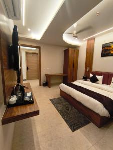 a bedroom with a large bed and a television in it at G RAK HOTELs in Etah