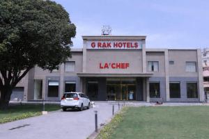 a car parked in front of a large building at G RAK HOTELs in Etah