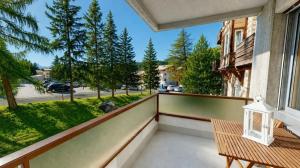 a balcony with a bench and a view of a street at Residenz Alpina im Kurhaus in Lenzerheide