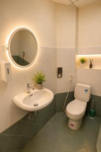 a bathroom with a sink and a toilet and a mirror at YT Hotel & Hostel Vientiane in Vientiane