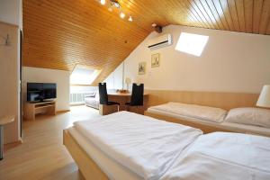 a bedroom with two beds and a wooden ceiling at Hotel-Garni-Kurtz in Reutlingen
