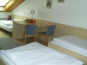 a room with a bed and a desk with two chairs at Hotel-Garni-Kurtz in Reutlingen
