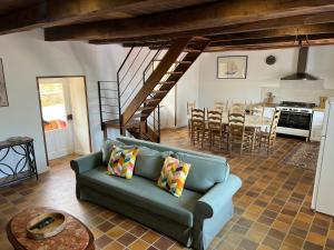 a living room with a blue couch and a kitchen at Moulin Mossaic in Glandon