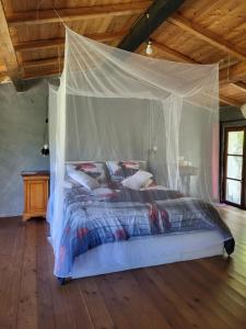 a bedroom with a bed with a mosquito net at Wild mountains in La Brigue