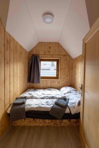 a bed in a small room with a window at Chata Michala in Dolný Kubín