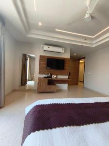 a hotel room with a bed and a flat screen tv at G RAK HOTELs in Etah