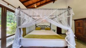 a bedroom with a bed with a canopy at Leaf Watagala in Avissawella +67 photos