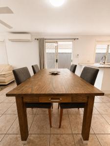 a wooden table and chairs in a living room at Pet Friendly close to Mooloolaba Sleeps 6 in Mountain Creek +5 photos