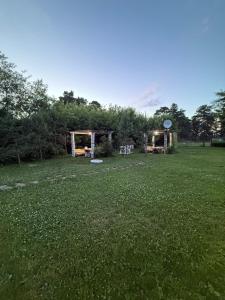 a grassy field with a gazebo in the background at Private in Shchūchīnsk