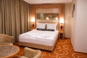 a hotel room with a bed and two chairs at Elbgalerie Hotel in Hamburg