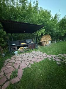 a stone patio with a grill in a yard at Private in Shchūchīnsk
