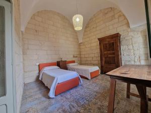 a room with two beds and a table in it at Dimora Pietra E Luce By Cala Salento in Vignacastrisi +54 photos