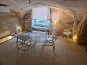 a dining room with a glass table and chairs at Dimora Pietra E Luce By Cala Salento in Vignacastrisi