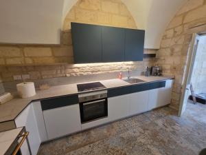 a kitchen with a sink and a counter top at Dimora Pietra E Luce By Cala Salento in Vignacastrisi