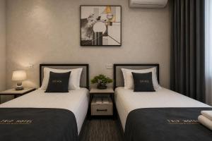 two beds sitting next to each other in a room at TRIP Hotel in Toshkent-Passajir Bekati
