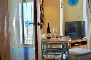 a room with a table with a bottle of wine and a glass at Superb Cintra Beachside Apartments in Llandudno