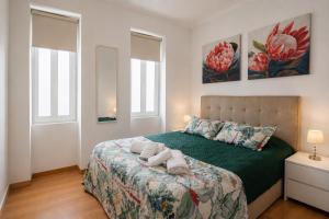 a bedroom with a bed with two towels on it at Faial Inn in Horta