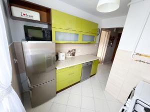 a kitchen with yellow cabinets and a stainless steel refrigerator at Apartament Staropijarska in Łuków