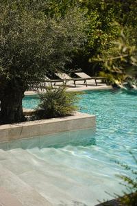 a pool of blue water with trees and benches at THERMA NUMERA Mineral SPA & Longevity in Burgas
