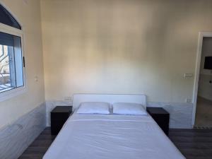 a white bed in a room with a window at Palm Serenity in Tangier