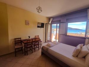 a bedroom with a bed and a table with a view of the ocean at Lavender Apartments in Skala Potamias