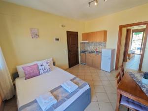a bedroom with a bed and a kitchen with a table at Lavender Apartments in Skala Potamias