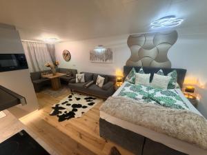a bedroom with a large bed and a couch at Emerald Alpine Apartment Seefeld in Seefeld in Tirol