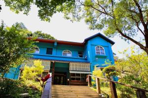 a blue house with stairs in front of it at Xiangyang Tianyuan in Sanyi