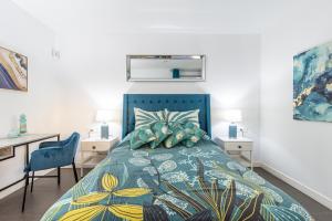 a bedroom with a bed with a blue bedspread at Ático de Lujo con Jacuzzi Privado en Azotea Vistas in La Oliva