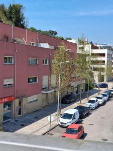a parking lot with cars parked in front of a building at Jardim da Guarda Inglesa in Santa Clara