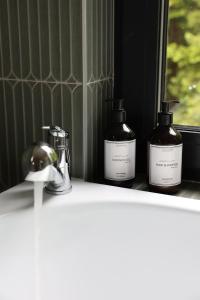 three bottles of soap sitting on a window sill at Зелено Східниця in Skhidnitsa +42 photos