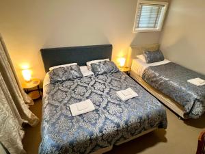a small bedroom with two beds with books on them at Bõucher Manor - Northam in Northam