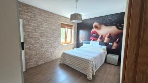 a bedroom with a bed and a wall with a picture of lips at Islabeach in Isla