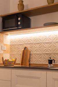 a kitchen counter with a microwave and a bowl of food at Orsola Apartments in Favignana