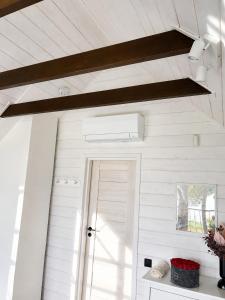 a white room with a door and a ceiling at Mäeküla Järve Palkmaja in Viljandi