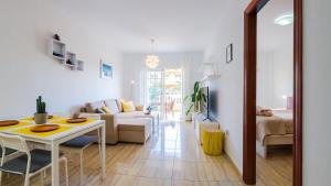 a living room with a table and a couch at Primavera apartment with heated pool in Palm-Mar