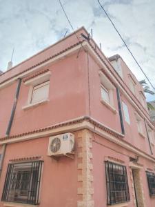 a pink building with windows on top of it at Oran ville in Oran