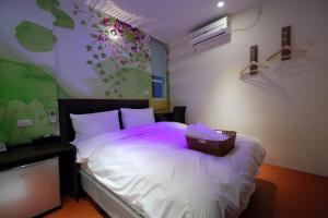 Happiness Inn في تايبيه: غرفة نوم بسرير ابيض عليها سلة