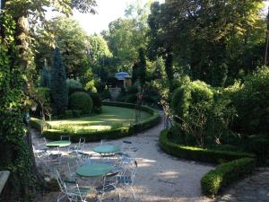 Buda Hills villa apartment في بودابست: حديقة بها كراسي وطاولات وطريق