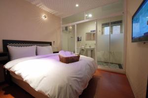 Happiness Inn في تايبيه: غرفة نوم بها سرير مع سلة عليه